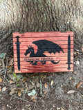 Wooden sign with dragon and swords design, labeled 'Dungeon Master', against a tree bark background.