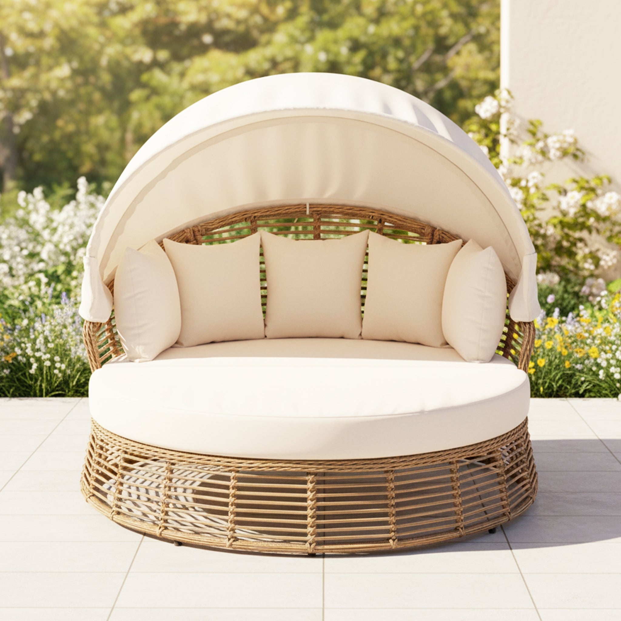 Round wicker daybed with beige cushions in a garden setting