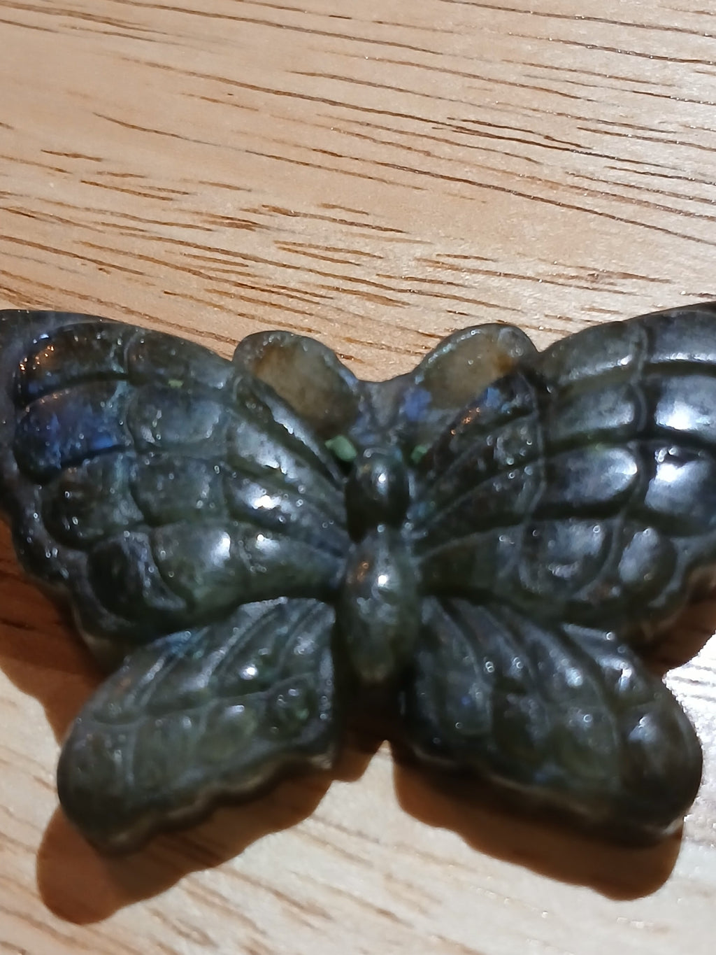 Metallic butterfly-shaped object on a wooden surface