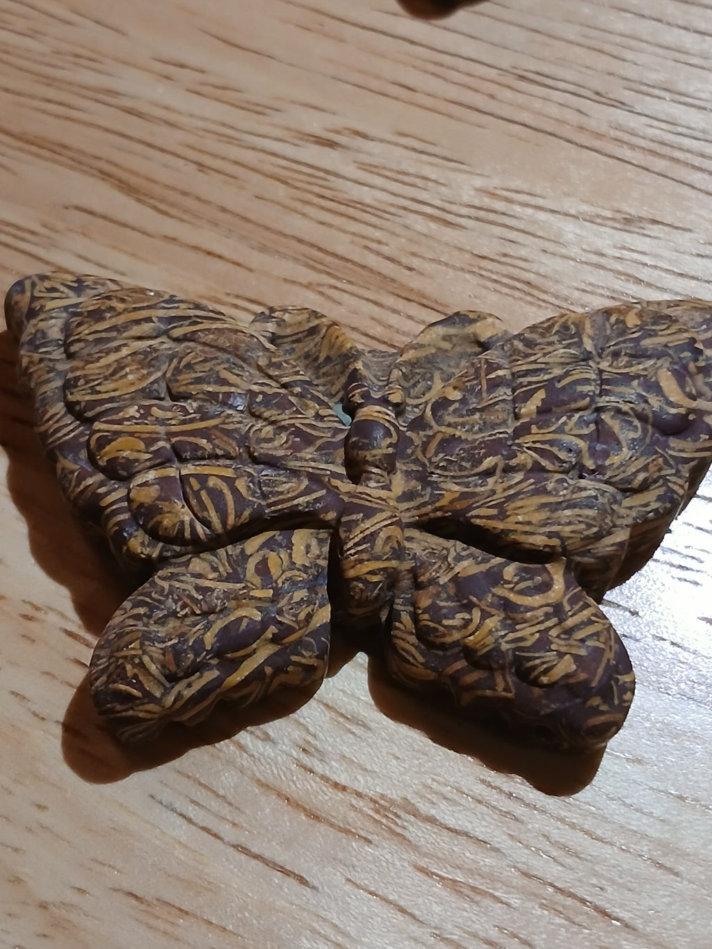 Wooden butterfly-shaped object on a wooden surface