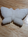 White butterfly-shaped object on a wooden surface
